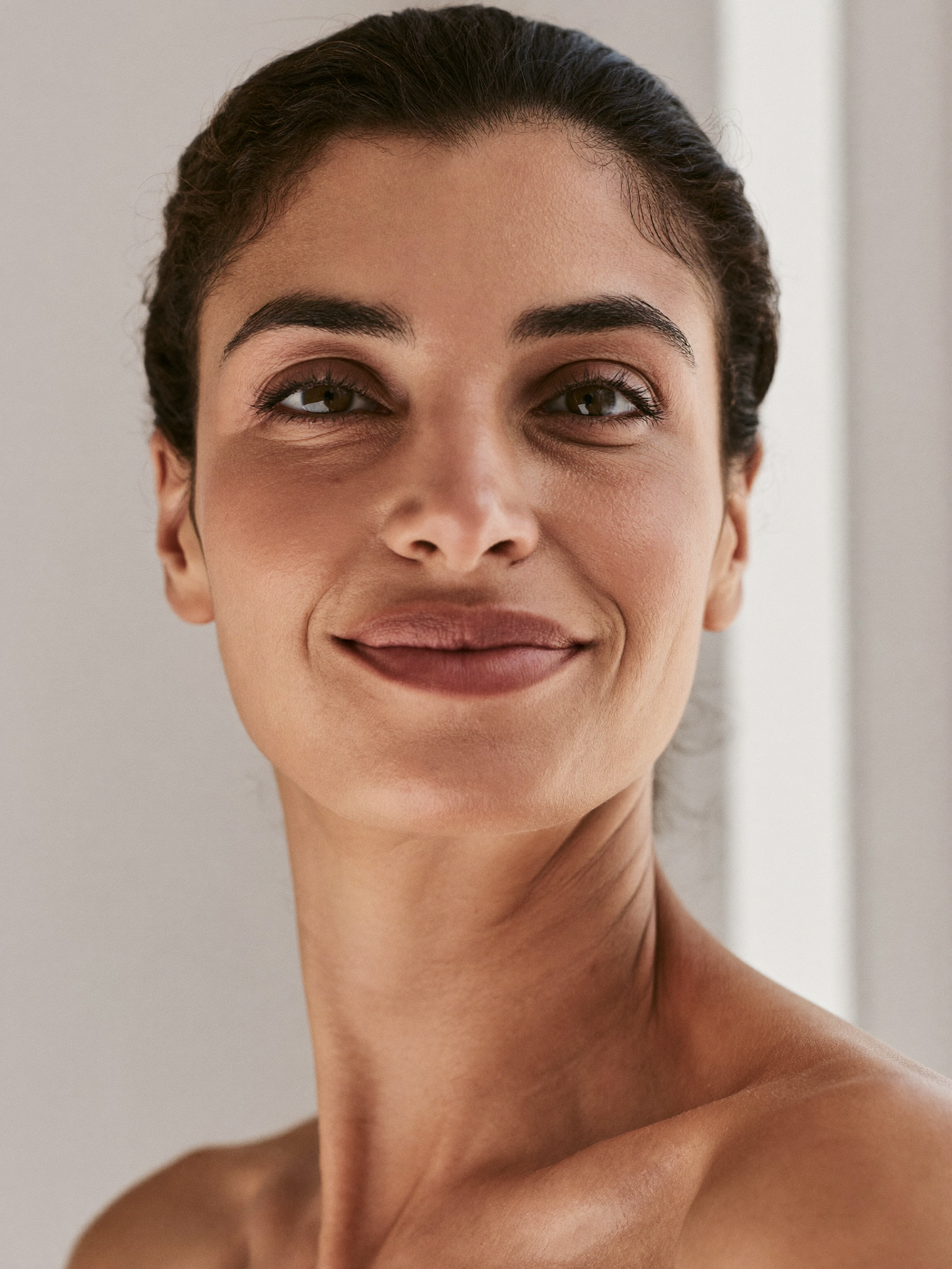 A naturally refreshed woman with bright, open, rested eyes in soft natural light — look as rested as you feel