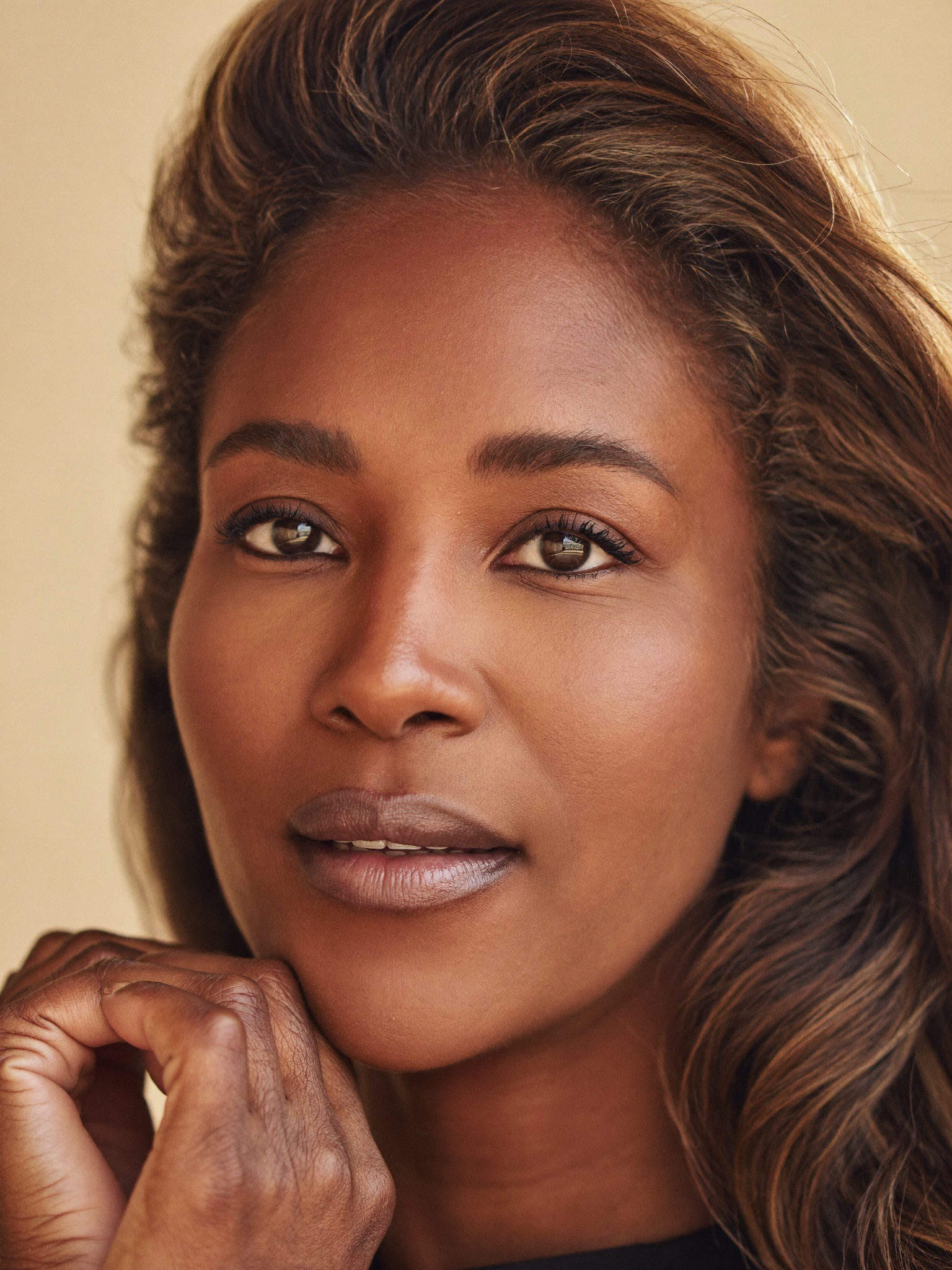 A graceful woman with calm, open, naturally refreshed eyes, at ease in warm light