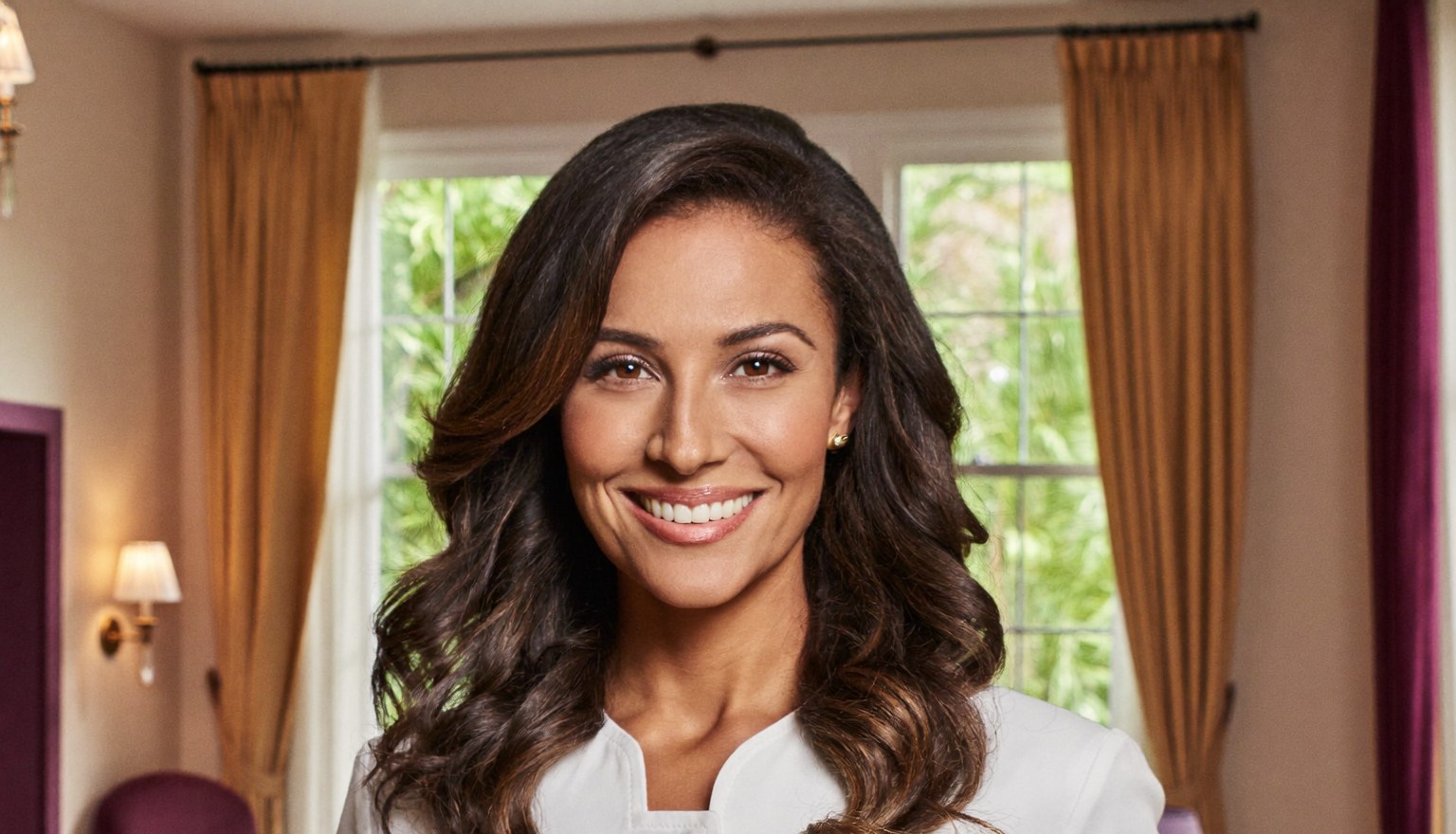 Dr. Elena Reyes, a warm, board-certified woman eyelid specialist, in her boutique consultation room