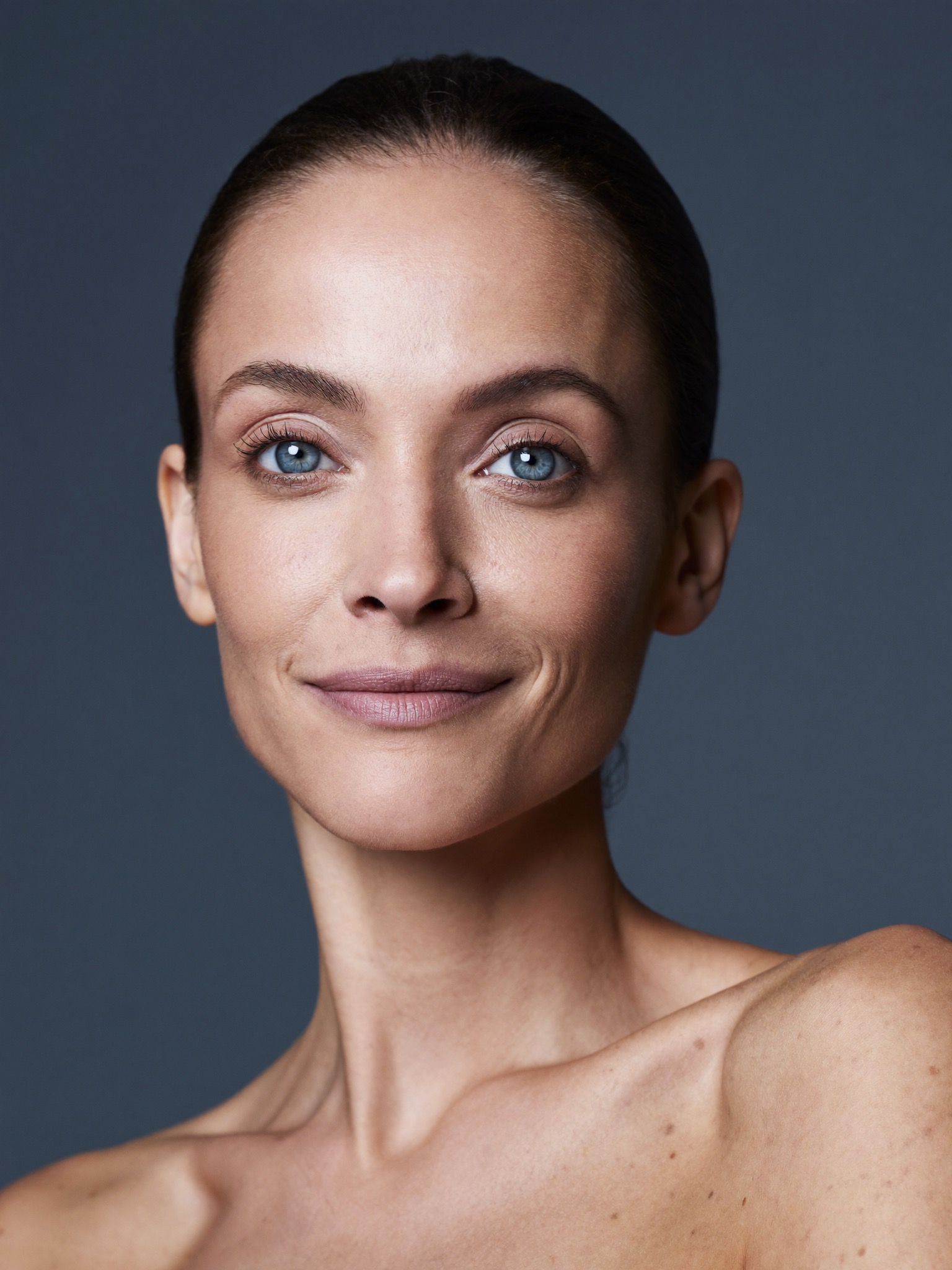 A naturally refreshed woman in her late forties with bright, rested, open eyes