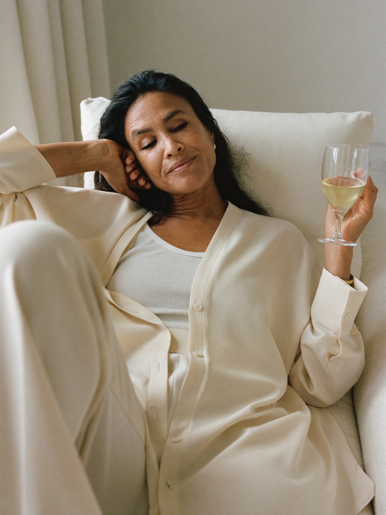 A woman recovered and at ease at home in natural light, looking rested.